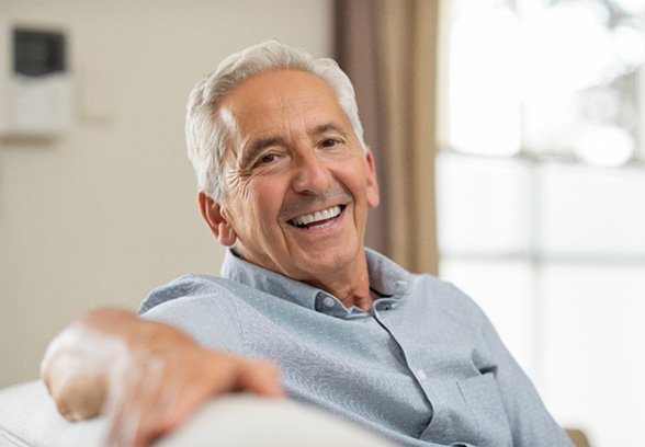 man smiling while sitting on couch