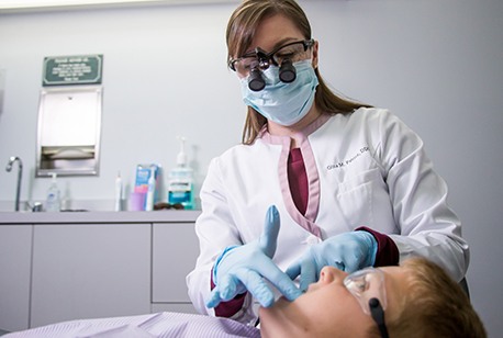 Dentist performing oral cancer screening