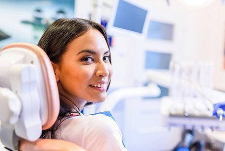 Woman smiling in dental chair looking back at camera