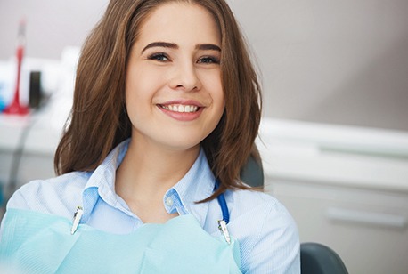 Woman smiling in dental chair with blue shirt