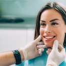 Dentist checking woman’s smile after cosmetic dentistry in Loveland, OH 