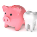 Piggy bank next to tooth representing cost of cosmetic dentistry in Loveland, OH