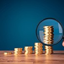Stacks of coins inspected with magnifying glass