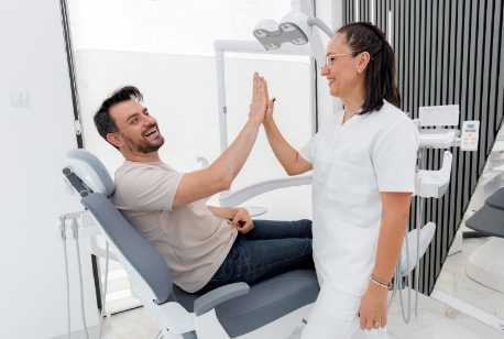 Patient high-fiving dental team member