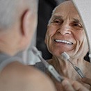 Man brushing his teeth in bathroom mirror