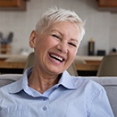woman smiling and sitting on the couch