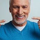 older man pointing to his restored smile