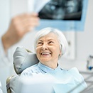 older woman smiling while looking at X-rays