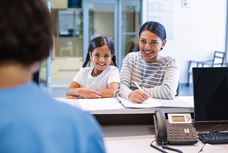 Mother and daughter checking in at dental office for emergency dentistry