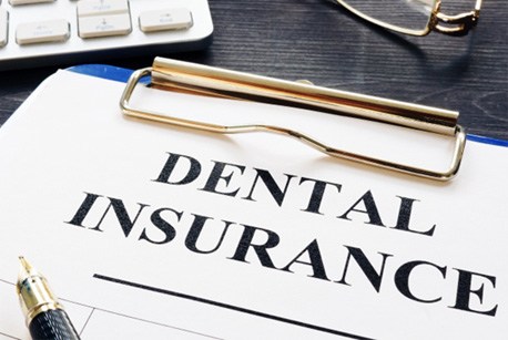 Dental insurance paperwork on a clipboard sitting on a counter