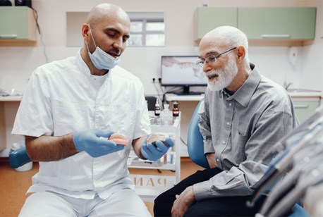 A dentist talking to his patient about implant dentures