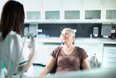 Woman speaking with an implant dentist in Loveland