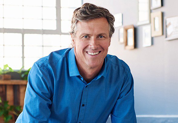 man in a blue button-down shirt smiling with dental implants in Loveland