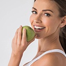 woman smiling with a green apple