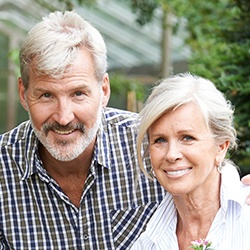 Older man and woman with healthy smiles thanks to periodontal therapy