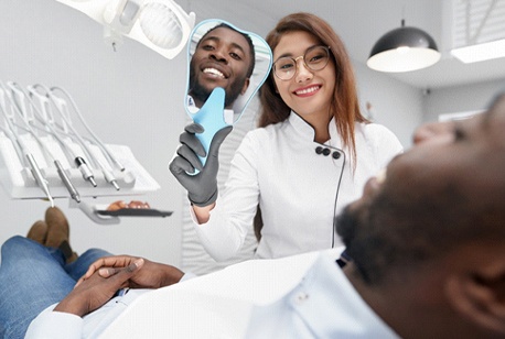 A dentist shows a male patient his new and improved smile thanks to cosmetic dentistry