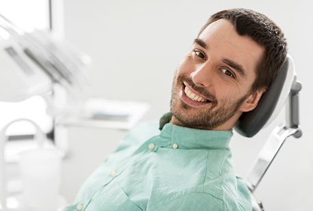 Man smiling in dental chair after TMJ treatment in Loveland, OH