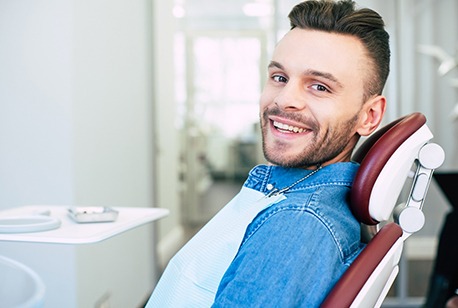 Male patient sitting up and smiling after TMJ treatment in Loveland, OH