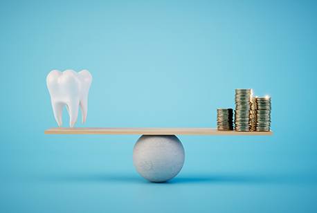 Tooth and pile of coins on a rudimentary scale