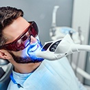Man undergoing in-office teeth whitening procedure
