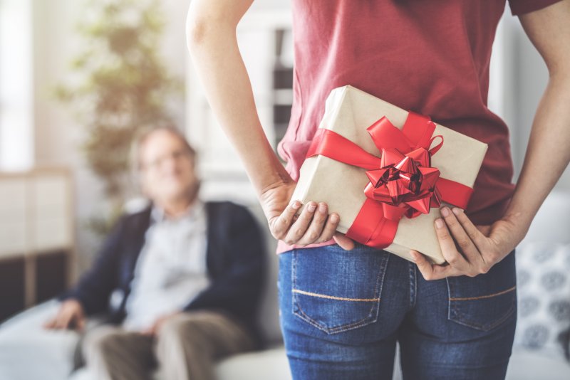 Closeup of woman hiding gift from family member