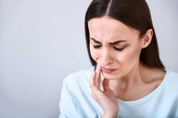 woman wincing with jaw pain