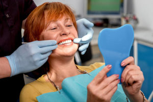 Older woman at dentist looking in a mirror